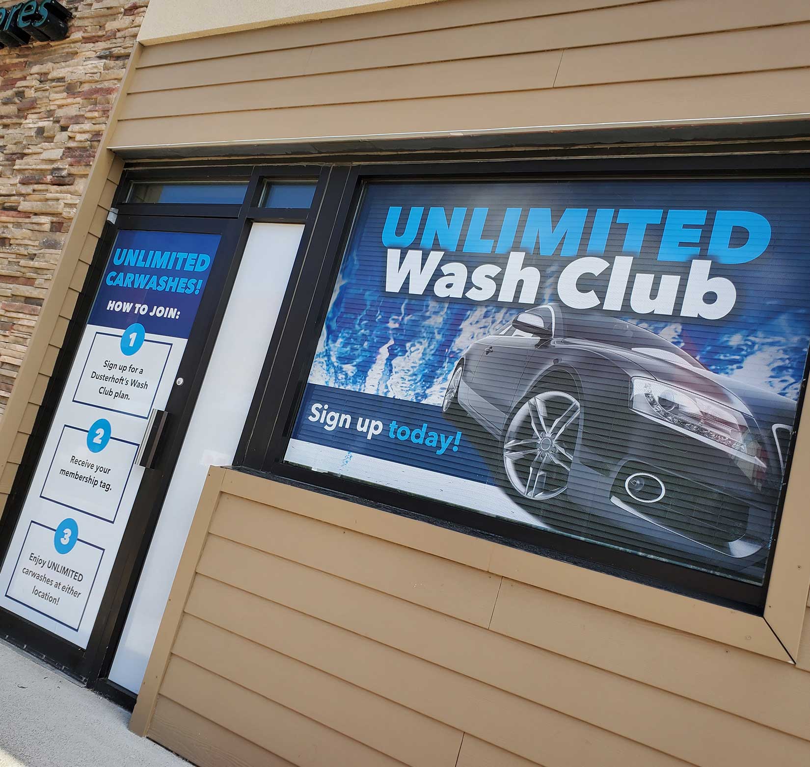 Exterior window signage promoting Dusterhoft Family Stores’ unlimited carwash club