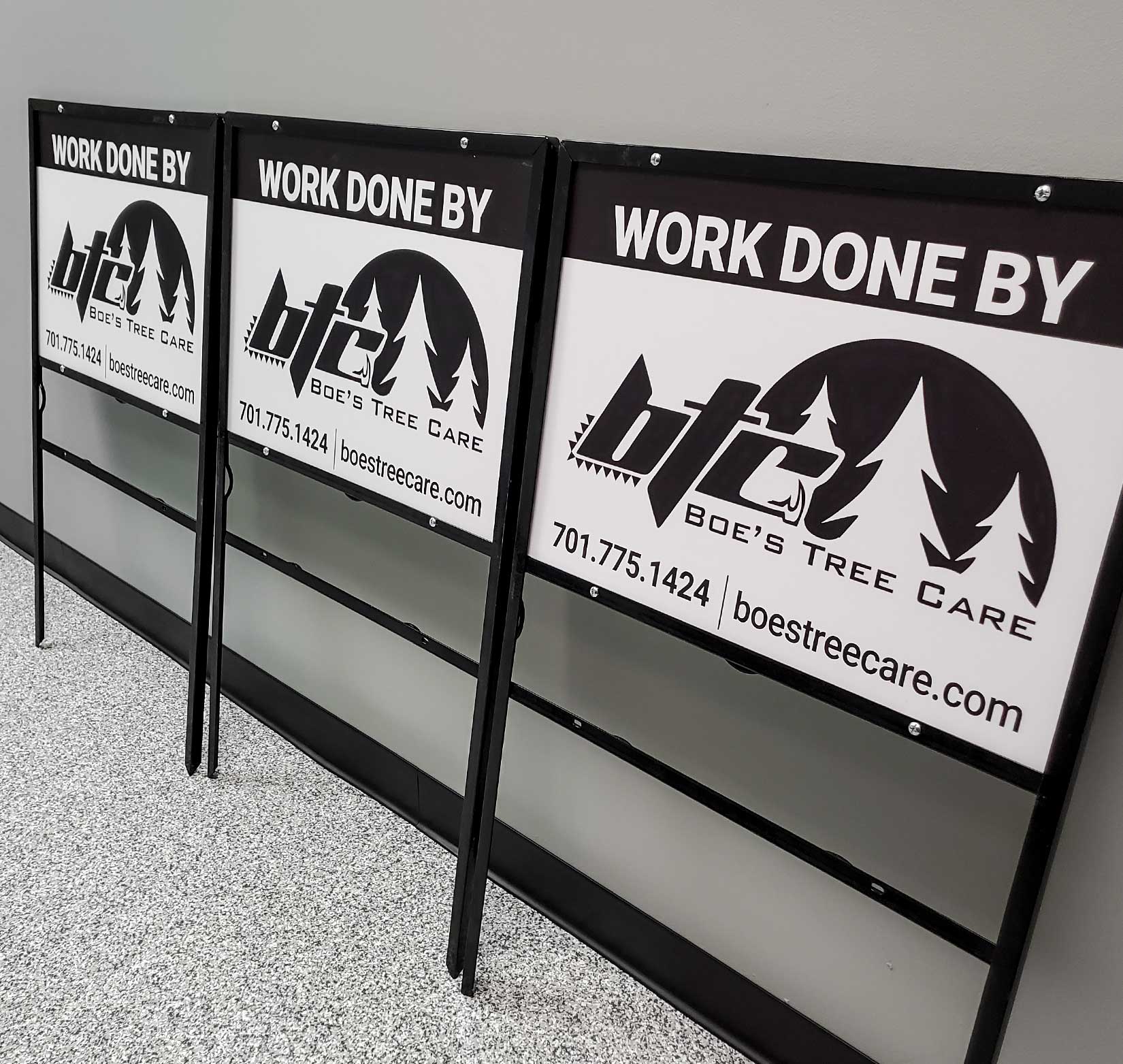 Three black and white yard signs for Boe’s Tree Care