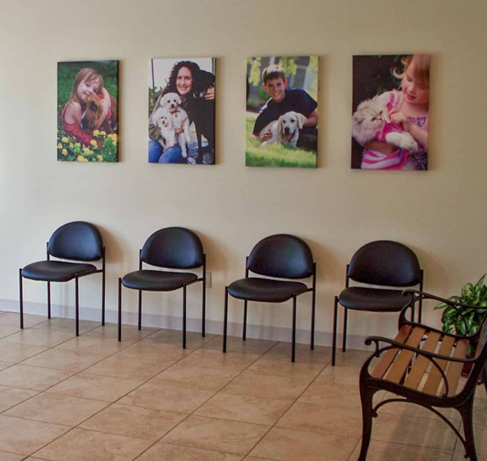 Four interior signs of people with their pets hanging in the lobby at Grand Valley Animal Hospital